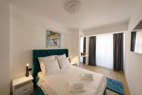 a bedroom with a large bed with a blue headboard at Castelana Infinity Beach Pool&Spa Mamaia Nord in Mamaia Sat/Năvodari