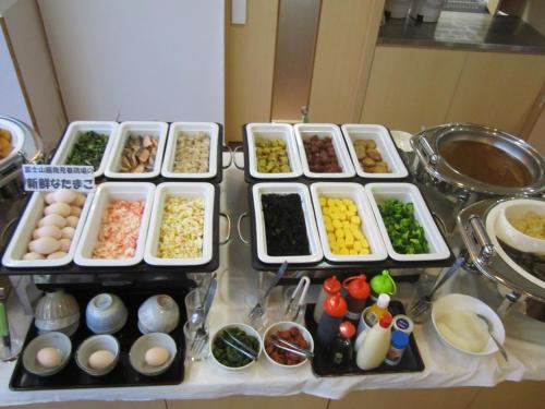 a table topped with trays of different types of food at Hotel Nishi In Fujisan in Fuji