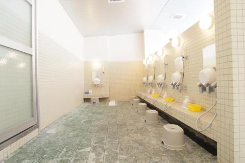 Hotel Nishi In Fujisan في فوجي: حمام به صف من المغاسل والمرايا