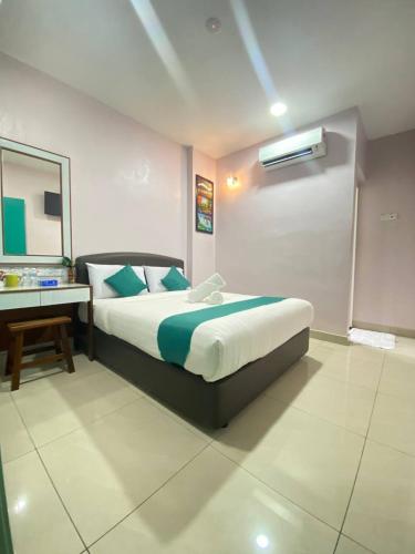 a bedroom with a bed and a desk in it at Sun Tree Hotel in Kampong Kerayong