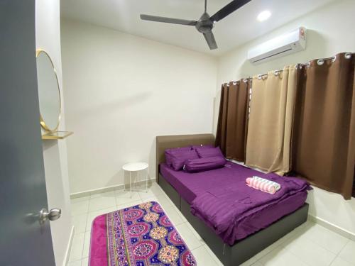AZALiA HOMESTAYMUSLIM TELUK INTAN في تيلوك إنتان: غرفة صغيرة مع سرير أرجواني وسجادة