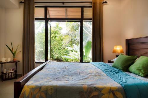 a bedroom with a bed with a large window at Kandy Tree Tops in Kandy