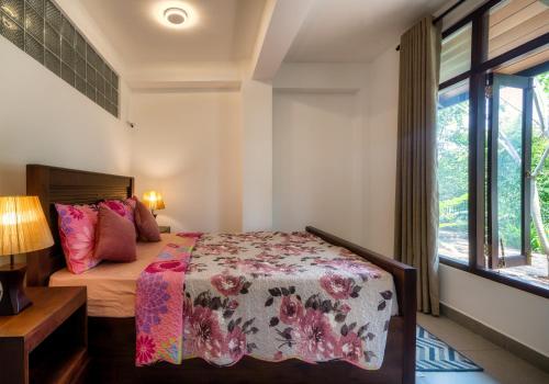 a bedroom with a bed and a window at Kandy Tree Tops in Kandy