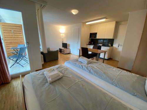 ein Schlafzimmer mit einem Bett und eine Küche mit einem Tisch in der Unterkunft Waldhof 1 - Waldhof 4 by Arosa Holiday in Arosa