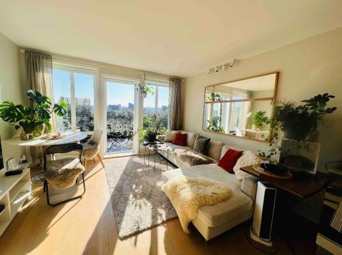 a living room with a couch and a large window at Central apartment with an amazing view in Oslo