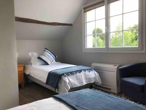 a bedroom with a bed and a chair and a window at Riverside Lodge in Chablis