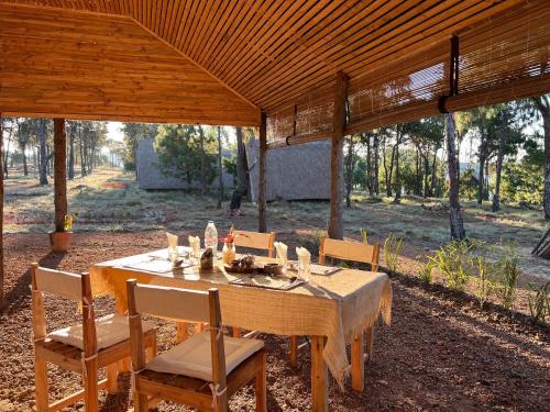 a wooden table and chairs under a wooden pavilion at TSIAZOMPANIRY ISLAND LODGE 