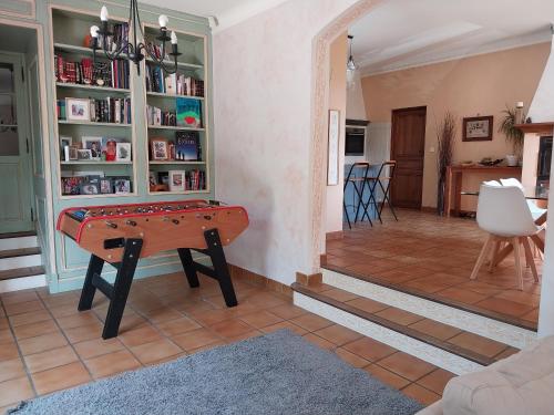 uma sala de estar com uma mesa e uma estante de livros em Jolie maison provençale. em Saint-Estève-Janson