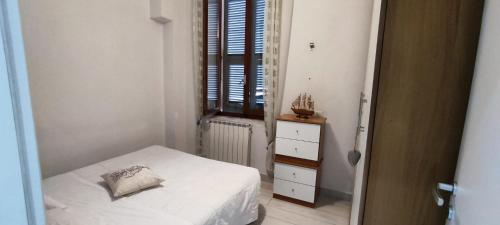 Habitación pequeña con cama y ventana en Casa Carlo en La Spezia