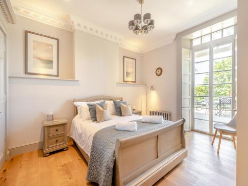 a bedroom with a large bed and a window at Mishmash in Arnside