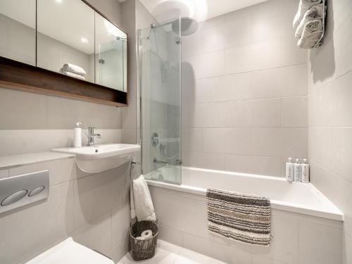 安賽德的住宿－Mishmash，白色的浴室设有水槽、浴缸和淋浴。