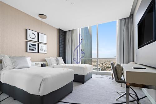 Habitación de hotel con 2 camas y escritorio en Walaa Homes-Luxury 2 Bedroom at DAMAC Exclusiva Tower Riyadh Saudia-3004, en Riad