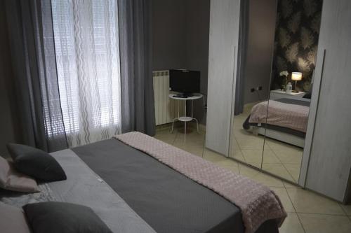 a bedroom with a mirror and a bed and a television at Fedro Domus (Vacanze Pompeiane) in Pompei