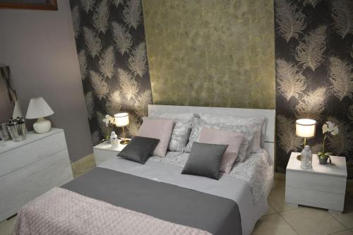 a bedroom with a bed with pink pillows and two lamps at Fedro Domus (Vacanze Pompeiane) in Pompei