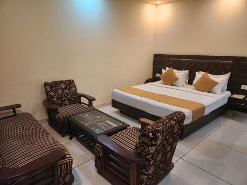 a hotel room with a bed and a chair at Hotel City Lite Near IGI Airport Delhi in New Delhi