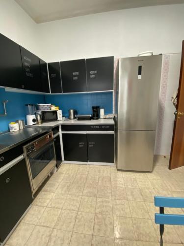 eine Küche mit einem Kühlschrank und Schränken aus Edelstahl in der Unterkunft Barão 35 Guest House in Braga