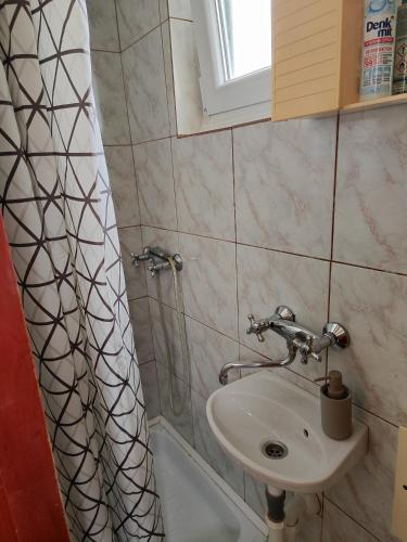 a bathroom with a sink and a shower curtain at Apartman Olja in Pag