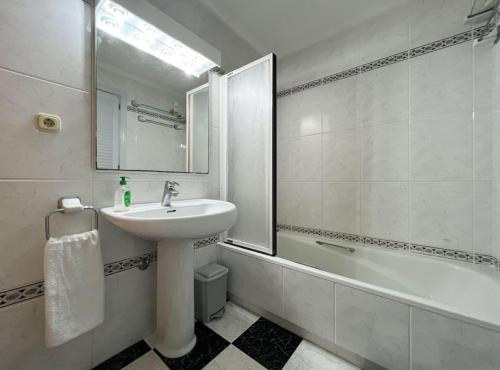 y baño con lavabo, espejo y bañera. en Apartamento en El Puerto de Santa María, en El Puerto de Santa María