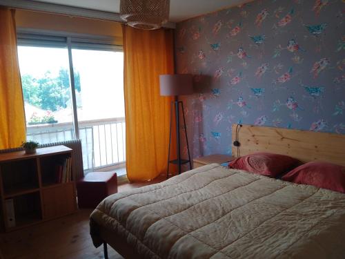 um quarto com uma cama com borboletas na parede em Appartement avec balcon : Le Serenity em Turckheim