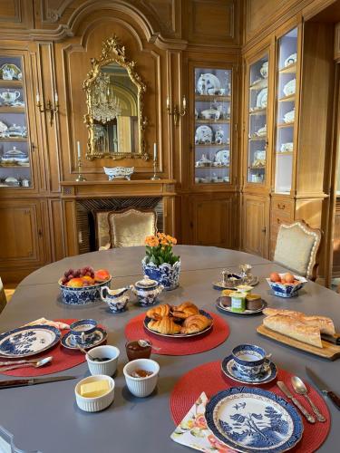 une table avec des assiettes et des bols de nourriture dans l'établissement Maison d'Hercule, à Mayenne