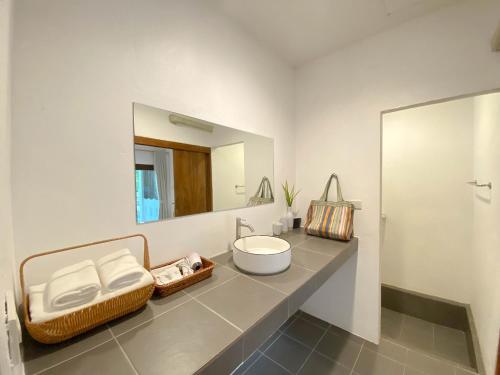 a bathroom with a sink and a mirror at Issara Beach Resort Beachfront in Sichon
