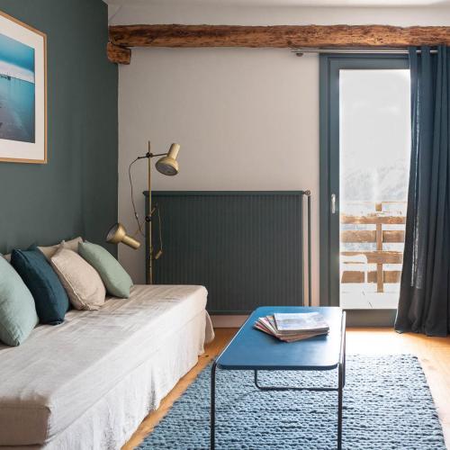 - une chambre avec un lit et une table bleue dans l'établissement Maison Cimes, aux Orres