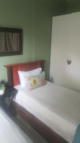 a bed with white sheets and pillows in a room at Porta Salutis in Port St Johns