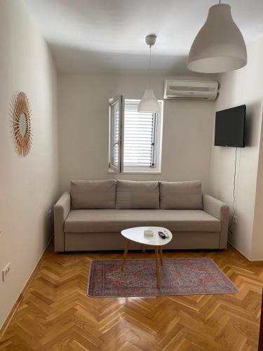 a living room with a couch and a table at First line Apartment Petrovac in Petrovac na Moru