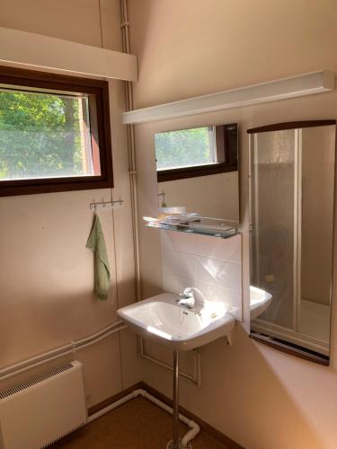 baño con lavabo, ventana y espejo en Sippolantie 11, en Kouvola