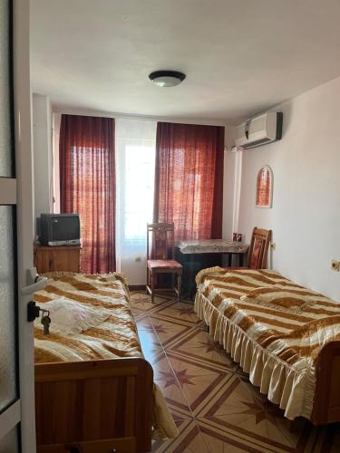 a hotel room with two beds and a table at Central Guesthouse in Nesebar