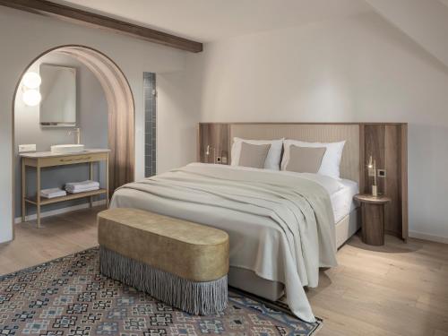 a bedroom with a large white bed and a table at Villa Helvetia in Merano