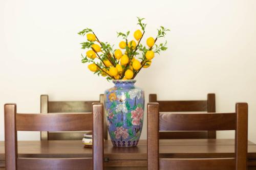 eine Vase mit Blumen auf einem Tisch mit zwei Stühlen in der Unterkunft Casa del Turista in Recco