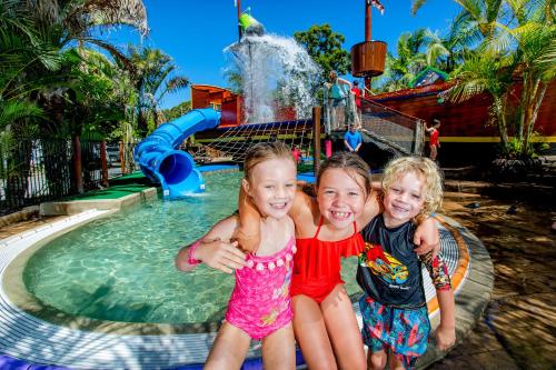 two little girls sitting next to a water park at NRMA South West Rocks Holiday Park in South West Rocks