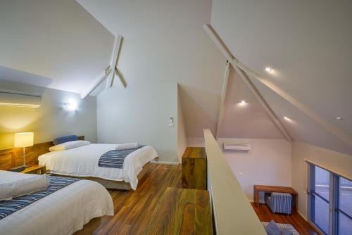 a attic bedroom with two beds and a staircase at Exmouth Escape Resort in Exmouth