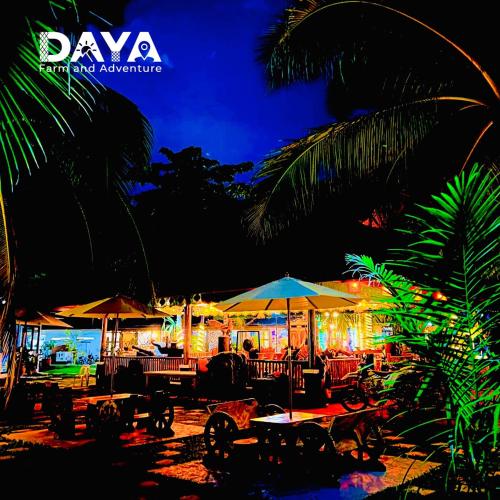 a beach with tables and umbrellas at night at Daya Farm and Adventure in Banay-Banay