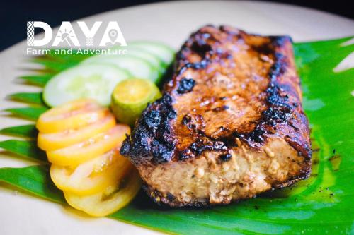 a plate of food with a piece of meat and fruit at Daya Farm and Adventure in Banay-Banay