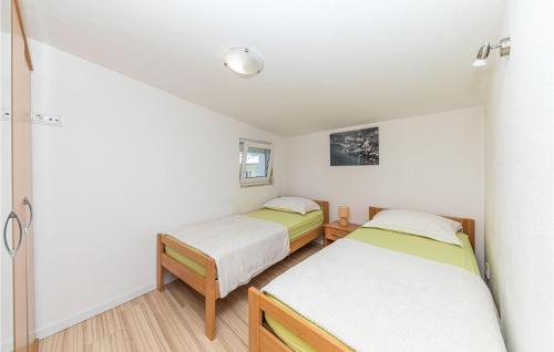 2 letti in una piccola camera con pareti bianche di 2 Bedroom Lovely Apartment In Kastel Gomilica a Kaštela (Castelli)