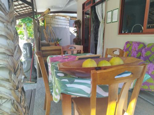 a table with a bowl of fruit on top of it at Tiki House in Bora Bora