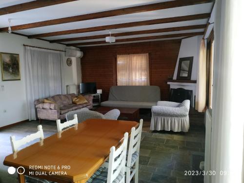 a living room with a table and a couch at House By The Sea in Artemida