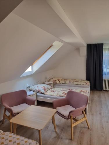 Zimmer mit einem Bett, 2 Stühlen und einem Tisch in der Unterkunft Penzion Hvozd in Nová Pec