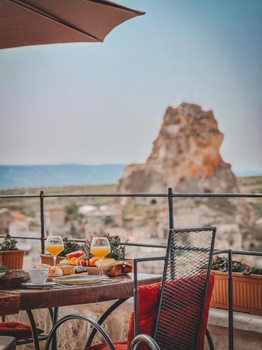 a table with a plate of food and glasses of orange juice at Cappadocia Vita Cave Hotel in Urgup
