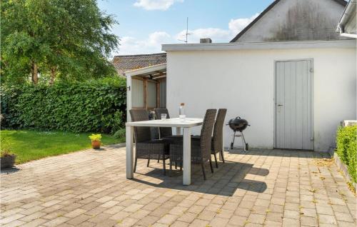 a patio with a table and chairs and a grill at 1 Bedroom Amazing Home In Bedsted Thy in Bedsted Thy