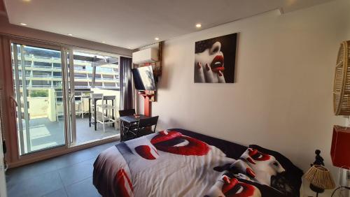 a bedroom with a bed with red shoes on it at Phantasme Naturiste Studio Terrasse Port Nature in Cap d'Agde