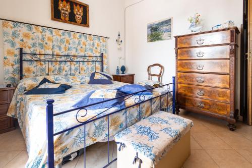 una camera con letto e cassettiera in legno di VILLA LORETTA LIPARI a Città di Lipari