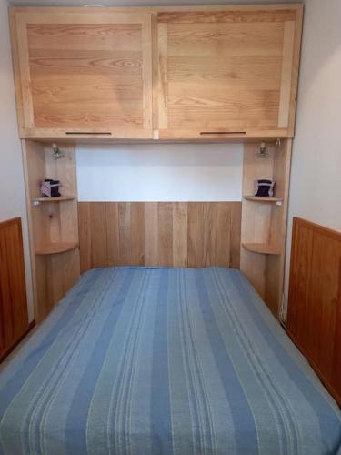 Ce lit se trouve dans un dortoir doté d'armoires en bois. dans l'établissement Super appt bord de mer avec piscine, à Argelès-sur-Mer