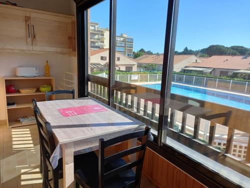 Cette chambre dispose d'une table et offre une vue sur la piscine. dans l'établissement Super appt bord de mer avec piscine, à Argelès-sur-Mer