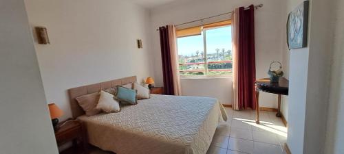 1 dormitorio con cama y ventana grande en Remarkable 1 Bedroom Apartment Costa da Caparica, en Costa da Caparica