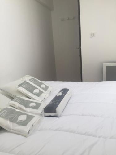 un groupe de télécommandes posées sur un lit blanc dans l'établissement appartement T2 proche du golf et de la plage, à Moliets-et-Maa