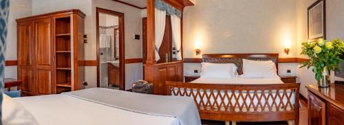 a bedroom with two beds and a cabinet at Hotel Villa Venezia in Grado
