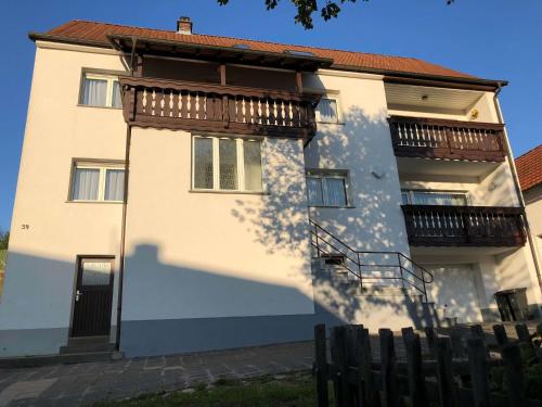 a white building with a balcony on the side at Gästehaus Lützelbach in Lützelbach
